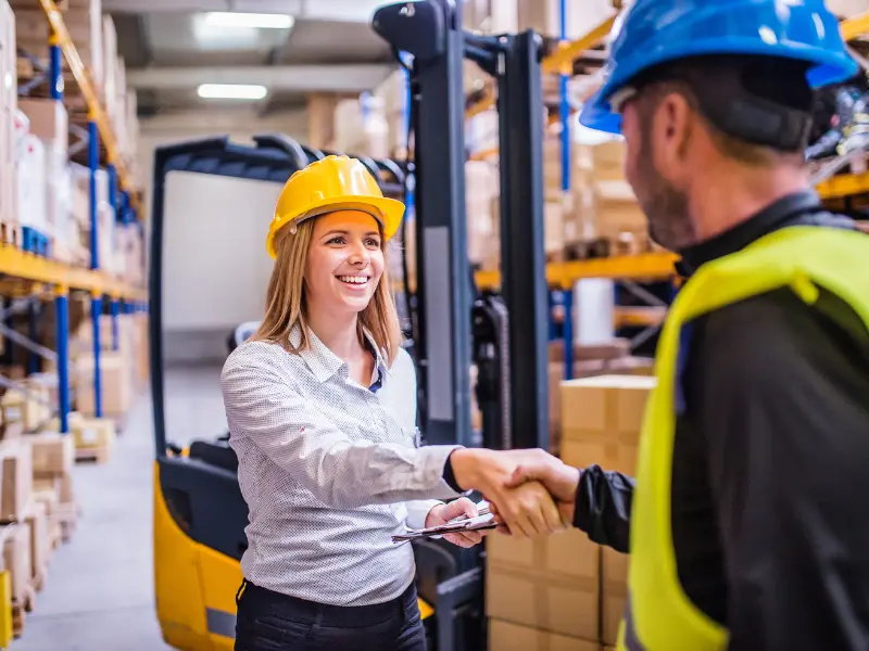 Two people in hard hats shaking hands