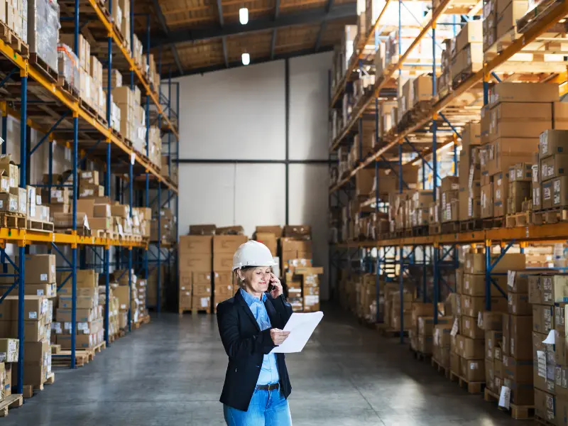 Woman in hard hat inside a warehouse