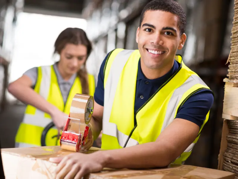 Two warehouse workers preparing boxes.